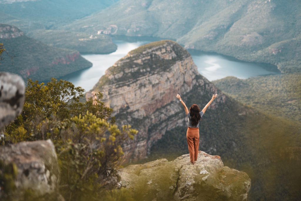 Woman standing on top of mountain