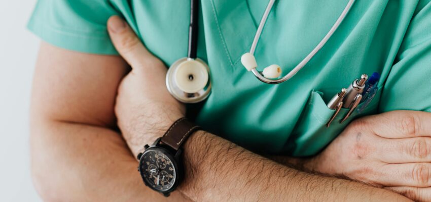 man in scrubs with arms crossed